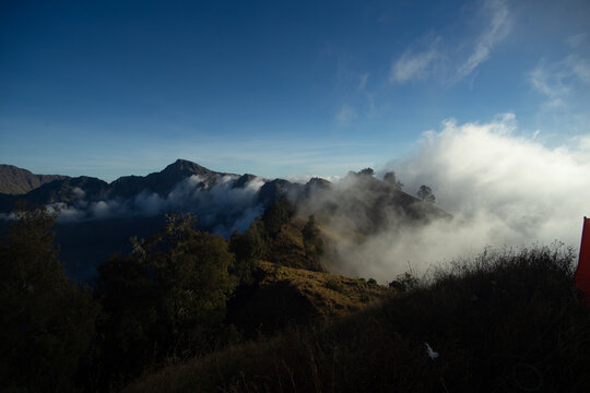 Misty mountains with clouds rolling over the forested hills at dawn
