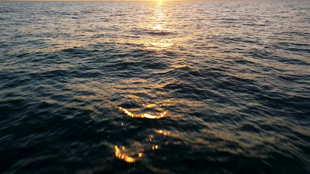 Aerial view of sunset horizon over the sea. Cinematic drone aerial view beautiful evening sunset in sky over sea.