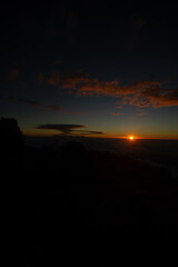 A serene sunset above the clouds with a warm glow on the horizon