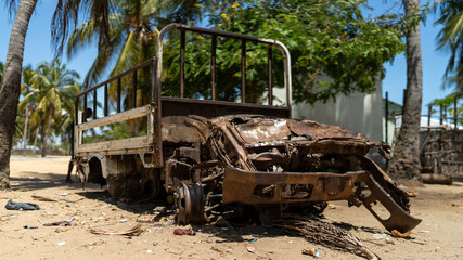 Fototapeta premium Abandoned and destroyed car in Mocimboa da Praia in Cabo Delgado, Mozambique
