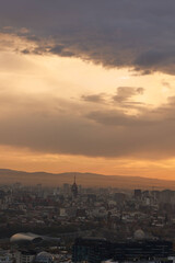 Fototapeta premium Scenic view of Tbilisi surrounded by majestic mountains in the distance at sunrise in Georgia