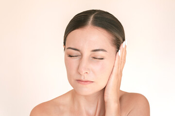 Young caucasian brunette woman is suffering from otitis. She experiencing acute pain in her ear, ...