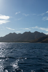 Serene seascape with majestic mountains in the background under a clear sky