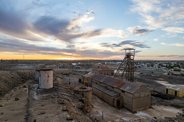 Fototapeta premium Disused abandoned mine shaft and buildings at Broken Hill's Line of Lode underground mine site at sunset - NSW, Australia