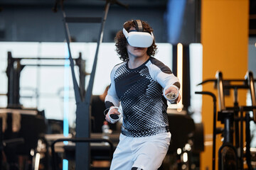 Waist up portrait of man wearing VR headset in gym enjoying immersive agility training copy space