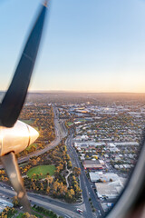 View from a plane window flying over Adelaide on approach at sunset