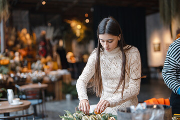 A gorgeous young lady enthusiastically participating in a holiday decoration workshop.