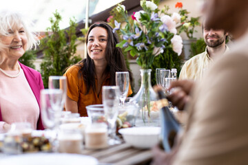 Storytelling image of a multiethnic group of people dining on a rooftop. Family and friends make a reunion at home ad dining outdoor.