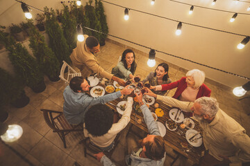 Storytelling image of a multiethnic group of people dining on a rooftop. Family and friends make a...