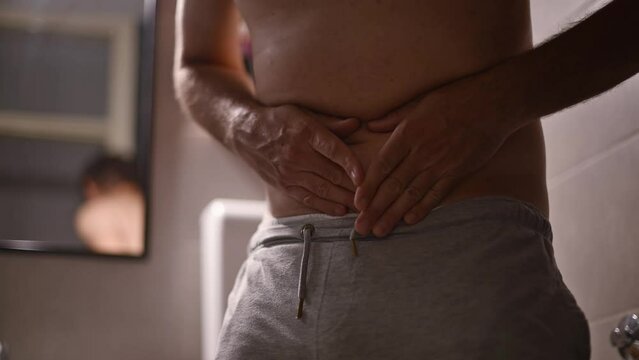 Dyspepsia, mature adult man with chronic indigestion symptoms of stomach pain in bathroom