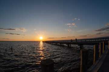 Obraz premium a pier over looking a wide open body of water at sunset