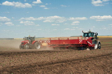 Obraz premium Riding, side view. Agricultural machinery, tractor on the field. Conception of harvest