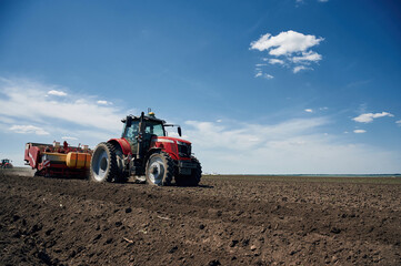 Obraz premium Riding, side view. Agricultural machinery, tractor on the field. Conception of harvest