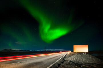 Copy space empty white road sign in Iceland. Car driving pass leave light trails on Icelandic...