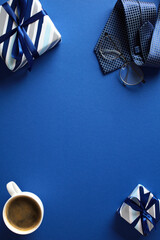 Blue Flat Lay with Gifts and Coffee. A vibrant image featuring a coffee cup, wrapped presents, tie, and glasses. Ideal for blogs, articles, and marketing materials about Fathers Day celebration
