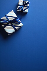 Elegantly wrapped gift boxes against a deep blue backdrop. Ideal for festive season promotions, greeting card designs, and marketing materials that require a touch of celebration