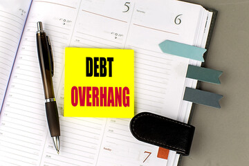 DEBT OVERHANG text sticky on dairy on gray background