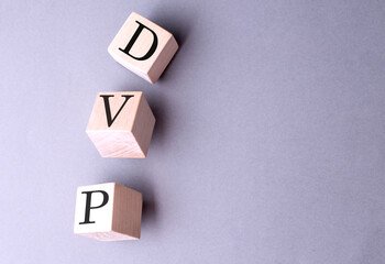 DVP word on wooden block on gray background