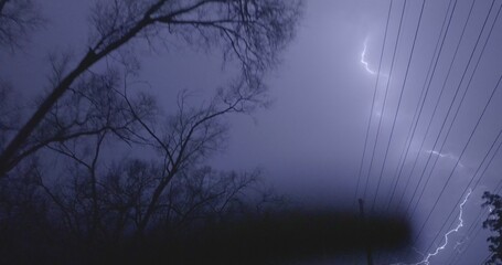 Strike behind power lines during an intense midwest April thunderstorm