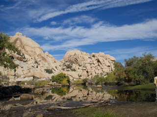 Group of rock formations in front of a lake surrounded by trees