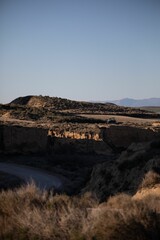 the mountains of a canyon that is filled with brown grass