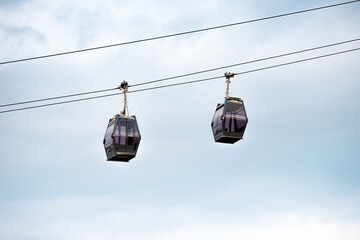 A cable car ascends to great heights, offering travelers a breathtaking view of the scenic mountain landscape below.