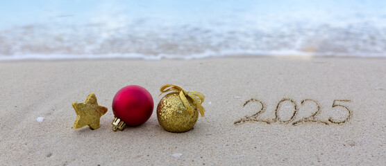 New Year 2025 handwritten in the white sand surface.