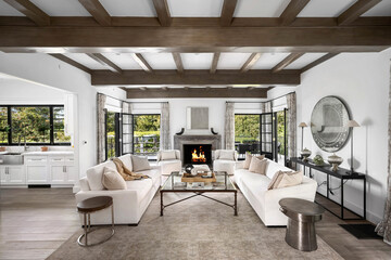 an open concept living area with two white sofas and a fireplace