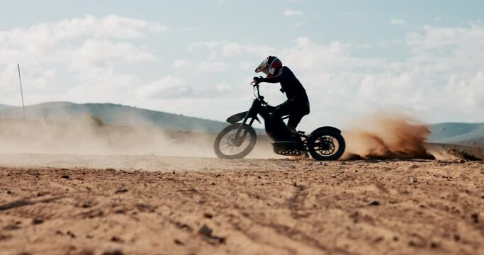 Biker, dirt or person spinning motorbike in outdoor training or celebration for extreme sports or success in desert. Dunes, sand or driver on electric bike for fun donuts in rally winning performance