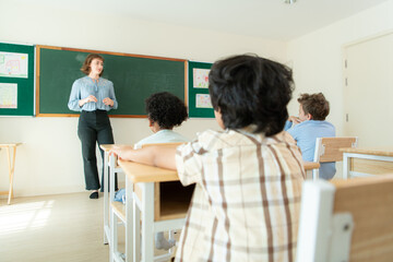 Teacher and students, Learn and study in a classroom of school where youngsters sit and listen attentively.