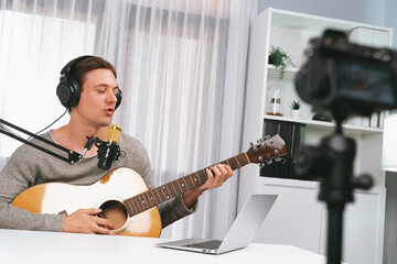 Host channel in smart singer recording by camera, playing guitar along singing, broadcasting on...