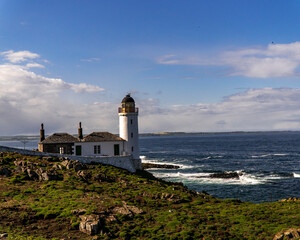 Picturesque lighthouse atop a cliff, overlooking the vast ocean on May Island