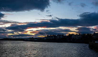 Picturesque coastal scene with charming seaside residences lining the sea wall at sunset