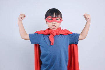 Asian Little Boy Wearing Superhero Costume Showing Strong Gesture