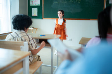 Children with classroom presentation activities in front of the classroom