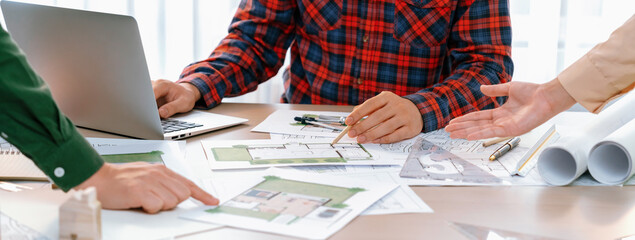 Professional architect design a blueprint by using laptop during project manager shows mistake...