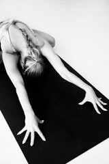 A woman stretches her back and arms in a yoga posture. Copy space