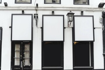 3 white signs on the wall of a beautiful apartment building,
