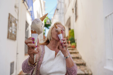an old female eating two ice cream. Health care with a diabetes and excessive glucose in summertime