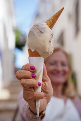 close up of a happy mature woman holding a ice cream.