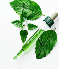 A green bottle of liquid with a green leaf on top