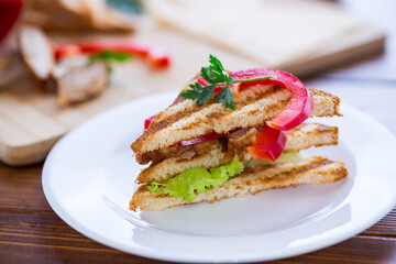 fried toast with chicken, salad, greens on a wooden table