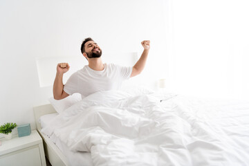 Photo of positive good mood guy awake in morning stretch fists in room house