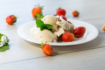 fresh organic cottage cheese with strawberries and ice cream in a plate on a wooden table
