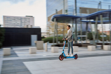 panning shot of a young businessman using his electric scooter to get around without polluting.