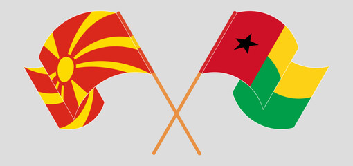 Crossed and waving flags of North Macedonia and Guinea-Bissau