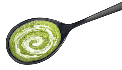 Spinach cream soup in black spoon isolated on white background, top view