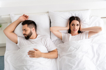 Photo of two people couple sleeping girl cover ears ignore snoring man sounds in home room