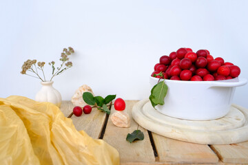 large white bowl with wild cherry plum, fresh juice fruit and berry on wooden boards, concept of...