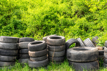 Used car tires thrown into the forest. Environmental pollution concept